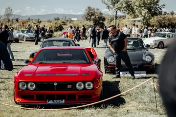Vista frontal y lateral de un Lancia clásico en una exhibición al aire libre