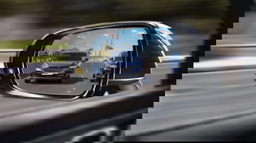 Reflejo de un vehículo en movimiento captado desde el espejo retrovisor.