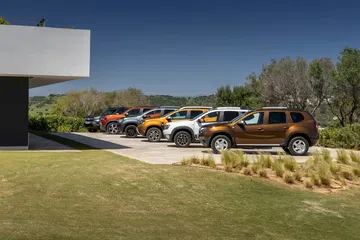 Vista de una fila de Dacia Duster aparcados en un entorno natural