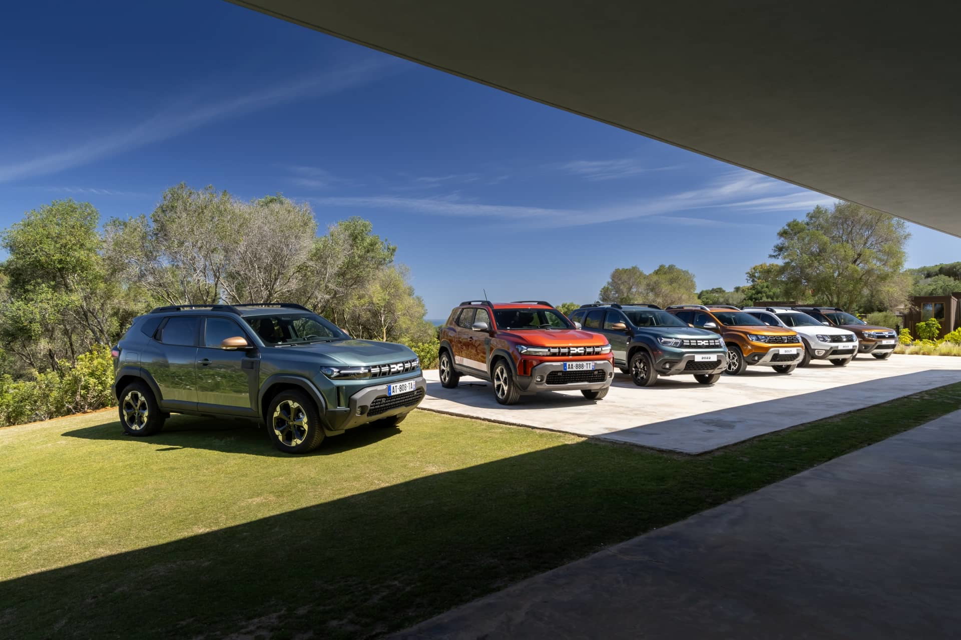 Vista lateral de una gama de Dacia Duster aparcados al aire libre.