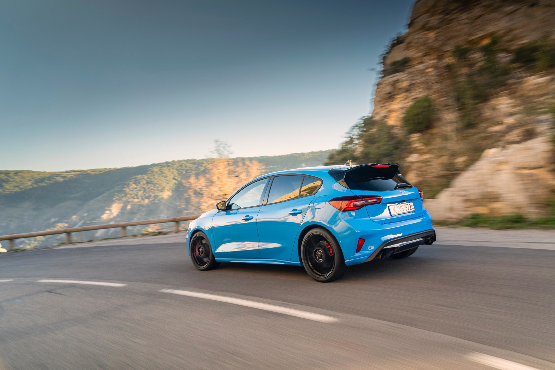 Vista trasera y lateral del Ford Focus ST 2024 en movimiento, destacando su diseño deportivo