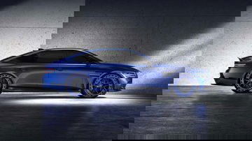 Vista lateral del Genesis G80 EV en color Magma, mostrando su elegante silueta y llantas deportivas.