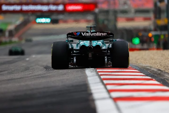 Monoplaza de F1 encarando curva con aerodinámica y neumáticos en detalle.