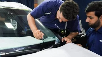 Técnico instalando película de nano-refrigeración en vehículo Hyundai