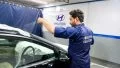 Técnico aplicando película de nanotecnología para refrigeración en vehículo Hyundai.