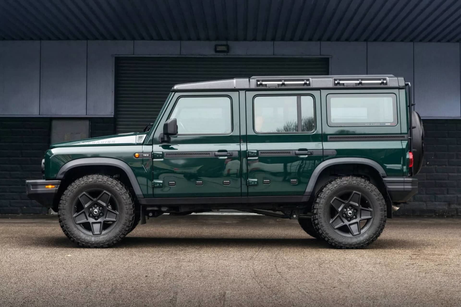 Vista lateral del Ineos Grenadier en un entorno urbano, destacando su diseño robusto y líneas clásicas.