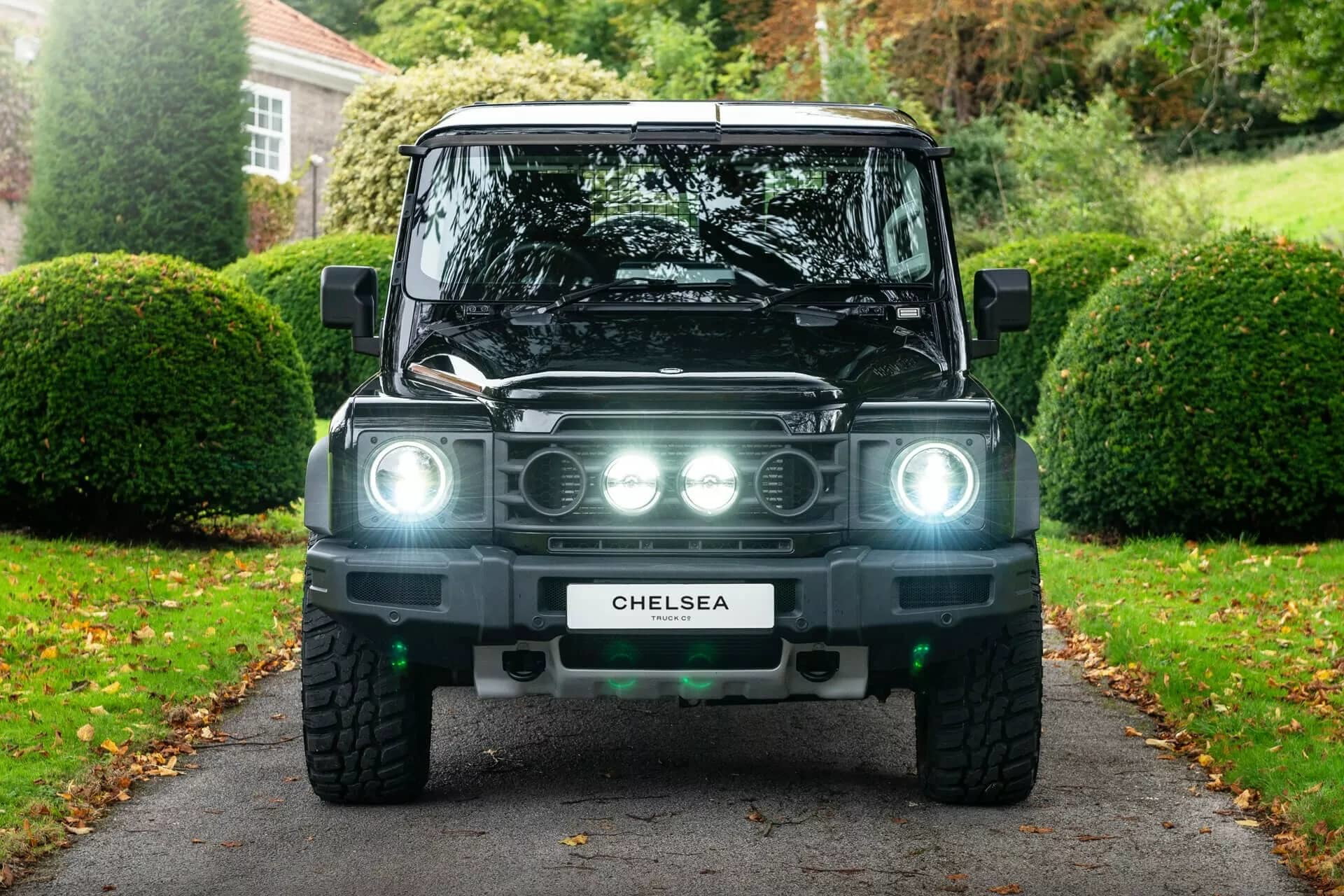 Vista frontal del Ineos Grenadier en entorno urbano, destacando su robusta estructura e iluminación LED.