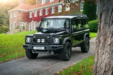 Vista frontal y lateral del INEOS Grenadier en ambiente selecto, mostrando su robustez y elegancia.