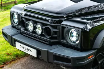 Vista delantera del Ineos Grenadier, destacando iluminación y parrilla.