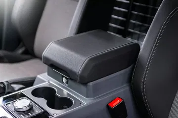 Consola central del Ineos Grenadier con enfoque en los portavasos y reposabrazos.