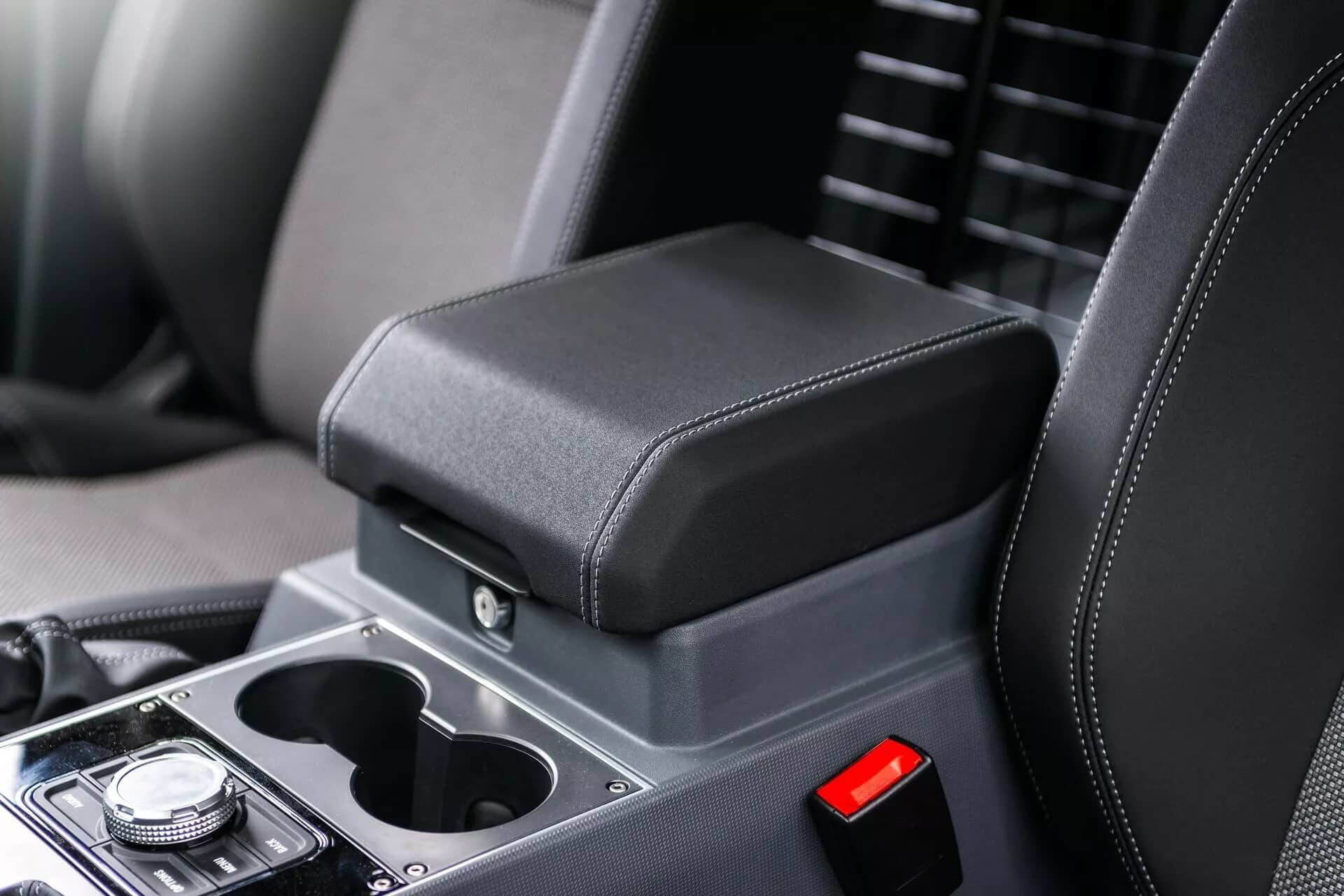 Consola central del Ineos Grenadier con enfoque en los portavasos y reposabrazos.