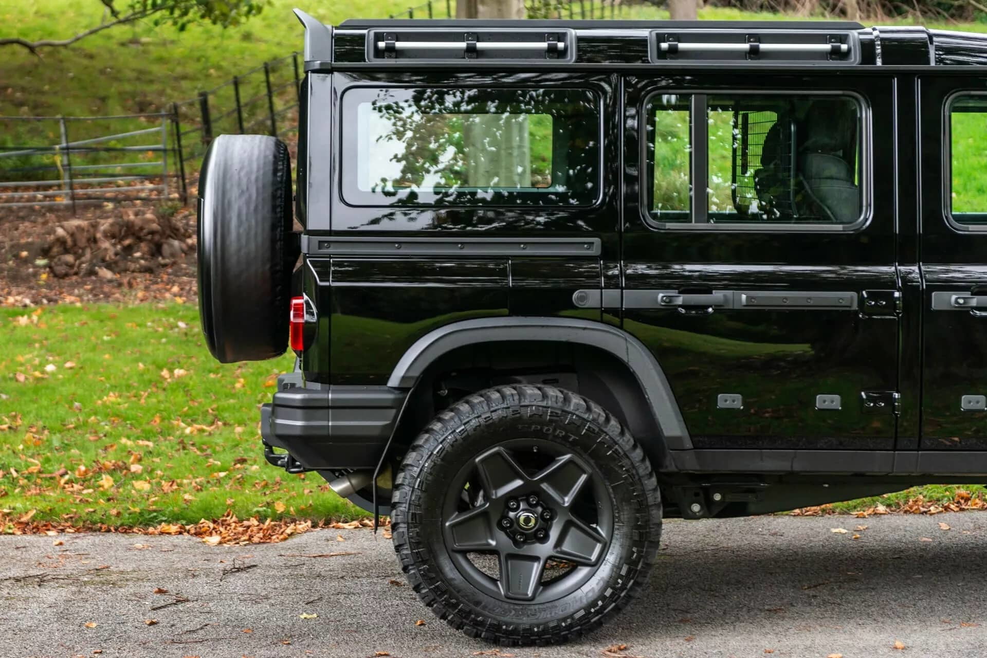 Vista lateral y trasera del Ineos Grenadier en su versión Chelsea 2024, mostrando el diseño robusto y la rueda de repuesto trasera.