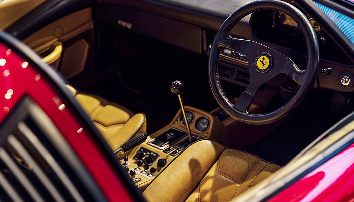 Vista lateral del habitáculo de un Ferrari clásico, con acabados en cuero.