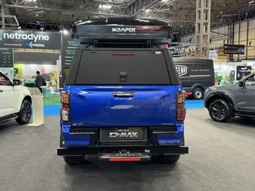 Vista trasera de un Isuzu D-Max con caja y equipo de acampada en el techo.