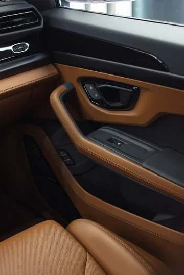 Vista del acabado en cuero de la puerta y zona de asientos del Lamborghini Urus SE 2024.