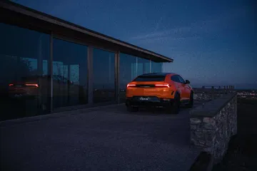 Vista nocturna del Lamborghini Urus SE 2024 destacando su diseño trasero y dinámica lateral.