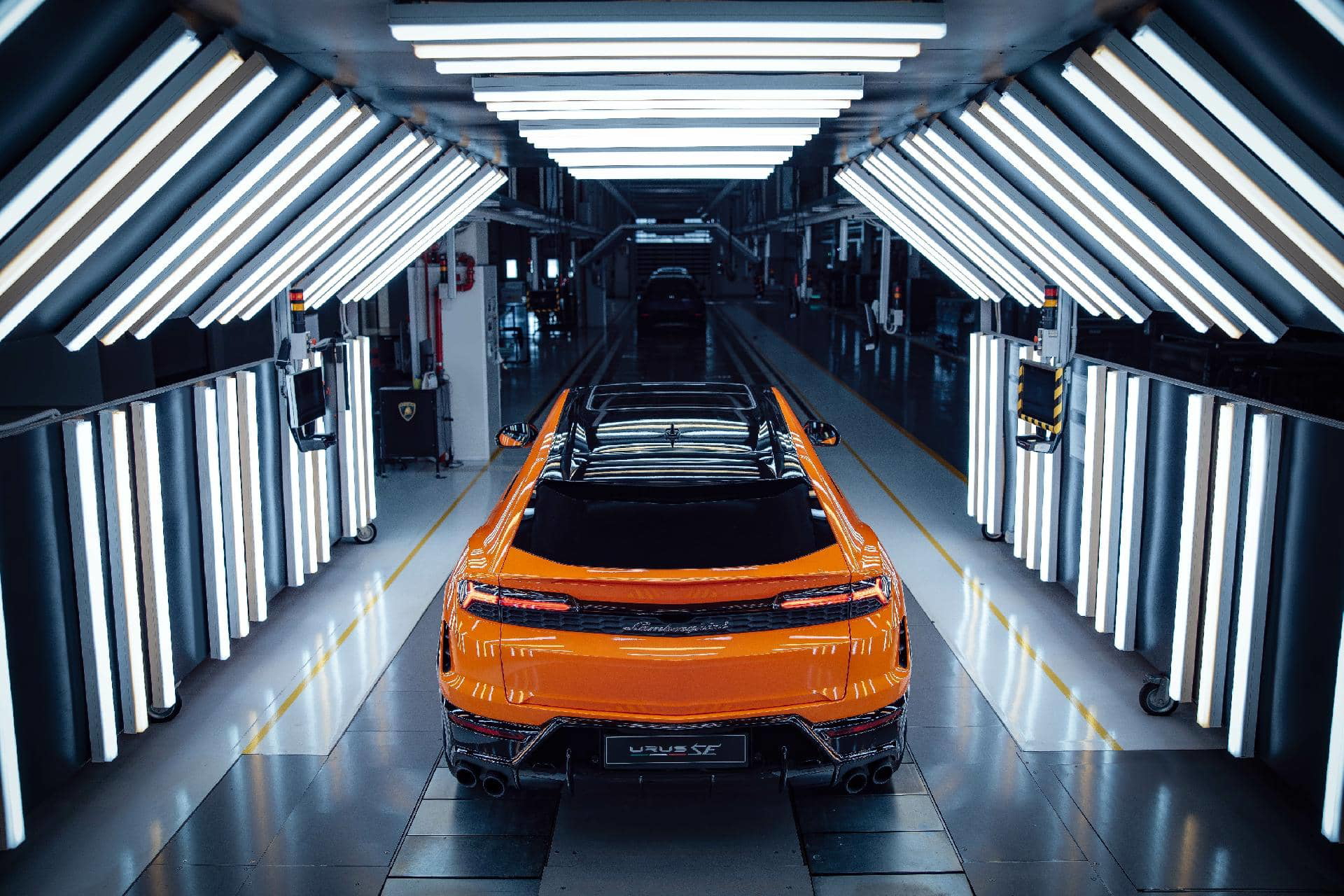 Vista trasera del Lamborghini Urus SE 2024 con iluminación en línea de producción.