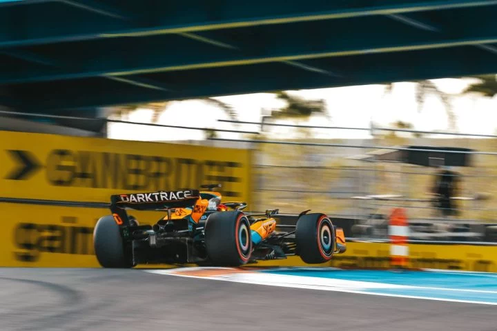 McLaren F1 2024 en acción, mostrando su perfil aerodinámico y librea distintiva.