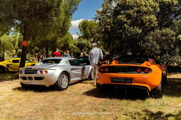 Vista de dos modelos Lotus en reunión de autos deportivos, enfatizando su diseño trasero y lateral