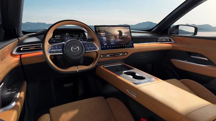 Vista del habitáculo del Mazda, destacando la ergonomía del volante y modernidad de la pantalla central.