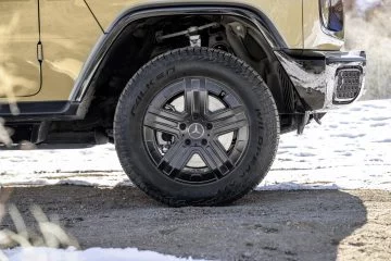 Rueda trasera y lateral del Mercedes Clase G 580 eléctrico sobre la nieve.
