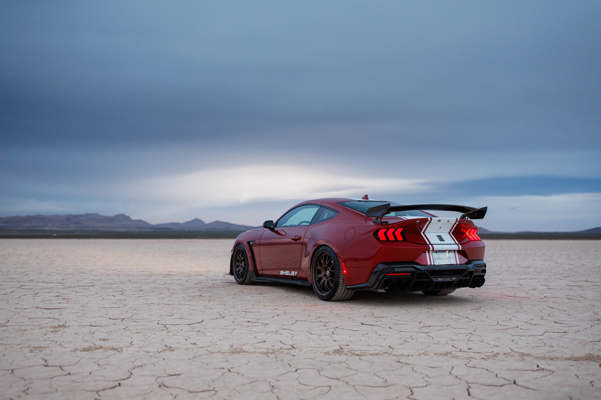Vista posterior y lateral de un Mustang Shelby GT500 en terreno desértico.