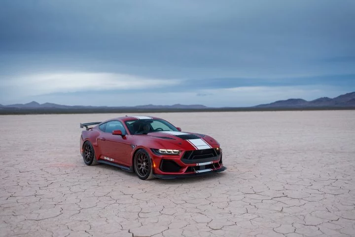 Vista frontal lateral de un Mustang Shelby GT500 posando en el desierto.