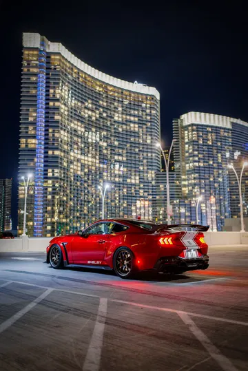 Mustang Shelby en rojo destacando su diseño lateral deportivo.
