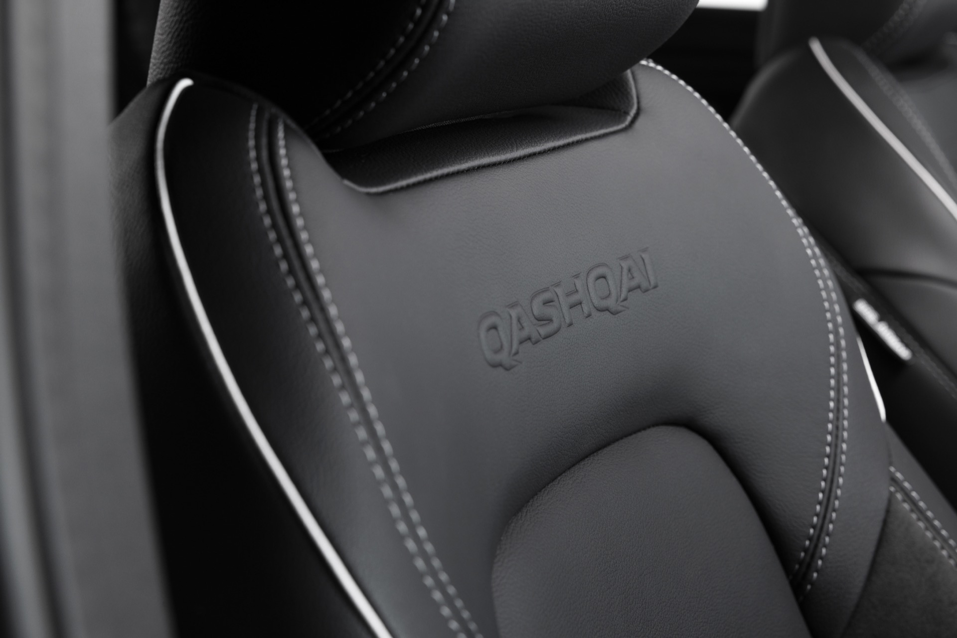Vista cercana asientos Nissan Qashqai 2024, destacando acabados y costuras
