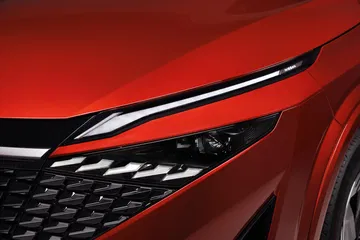 Vista en detalle de la óptica avanzada del Nissan Qashqai 2024, en acabado rojo vibrante.