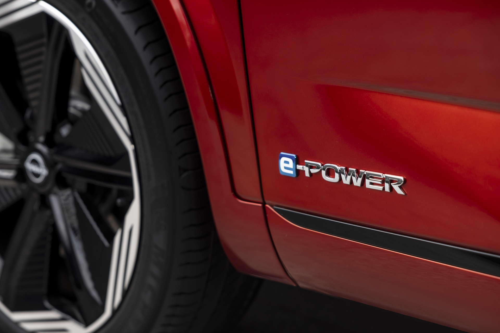 Vista del emblema e-Power en Nissan Qashqai 2024 con pintura roja.
