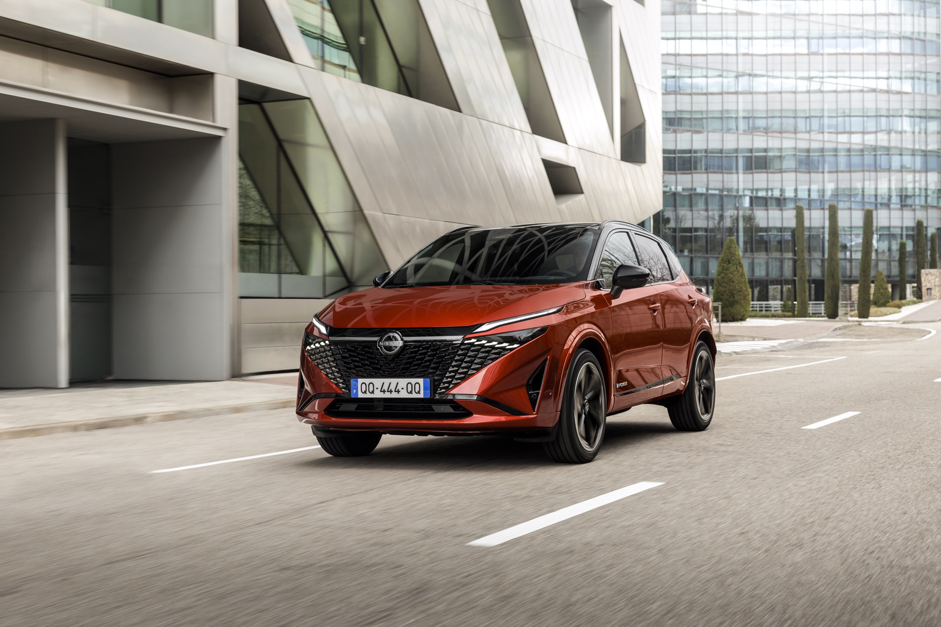 Vista dinámica del Nissan Qashqai 2024 en movimiento, destacando su diseño frontal y lateral.