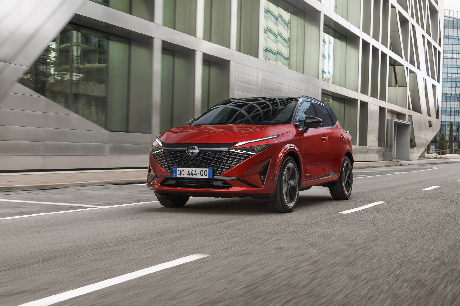 Vista dinámica del Nissan Qashqai 2024 en tono rojo, destacando su diseño frontal y perfil lateral.