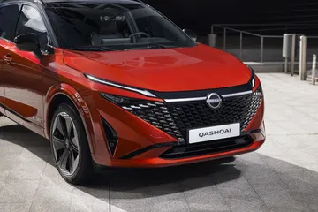 Vista delantera y lateral del Nissan Qashqai 2024 en color rojo, destacando su diseño vanguardista.