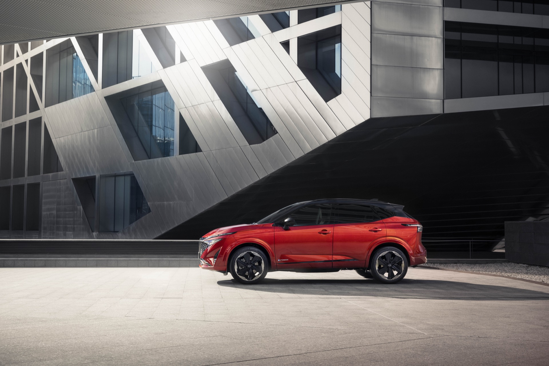 Vista lateral del Nissan Qashqai 2024 en color rojo, destacando su diseño aerodinámico.