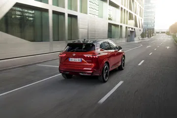 Vista dinámica del Nissan Qashqai 2024 en acabado rojo, destacando su diseño y proporciones.