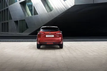 Vista posterior del Nissan Qashqai 2024 en color rojo, destacando su diseño moderno y líneas dinámicas.