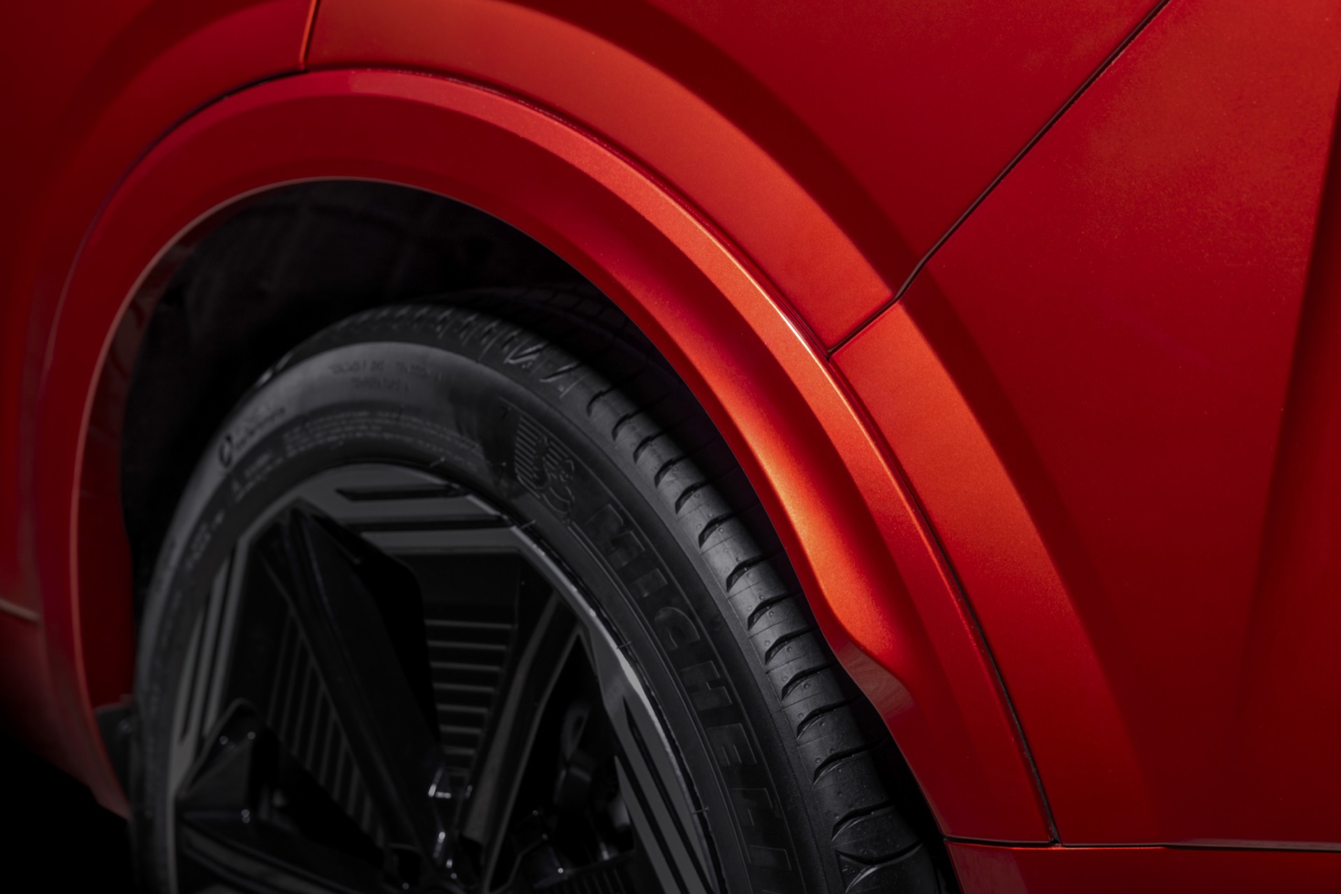 Vista del perfil lateral y detalle de la llanta del Nissan Qashqai 2024 en color rojo.