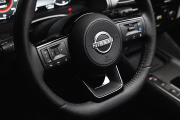 Vista cercana del volante y controles del Nissan Qashqai 2024, destacando su diseño ergonómico y calidad de materiales.