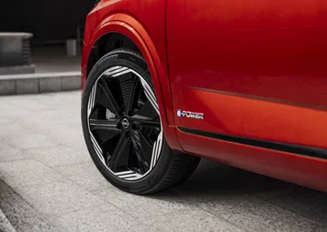 Detalle de la llanta y parte lateral del Nissan Qashqai 2024 en color rojo.