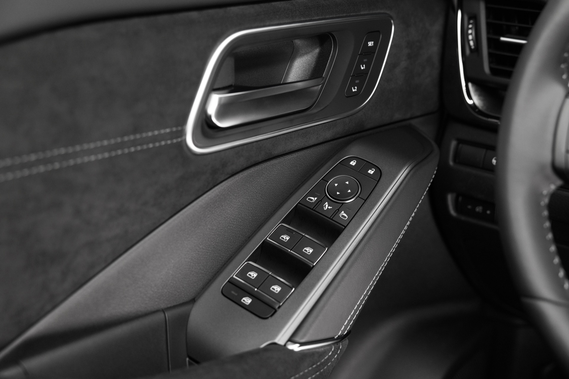 Vista cercana de los mandos de la puerta del Nissan Qashqai 2024, con ajustes de ventanas y espejos.