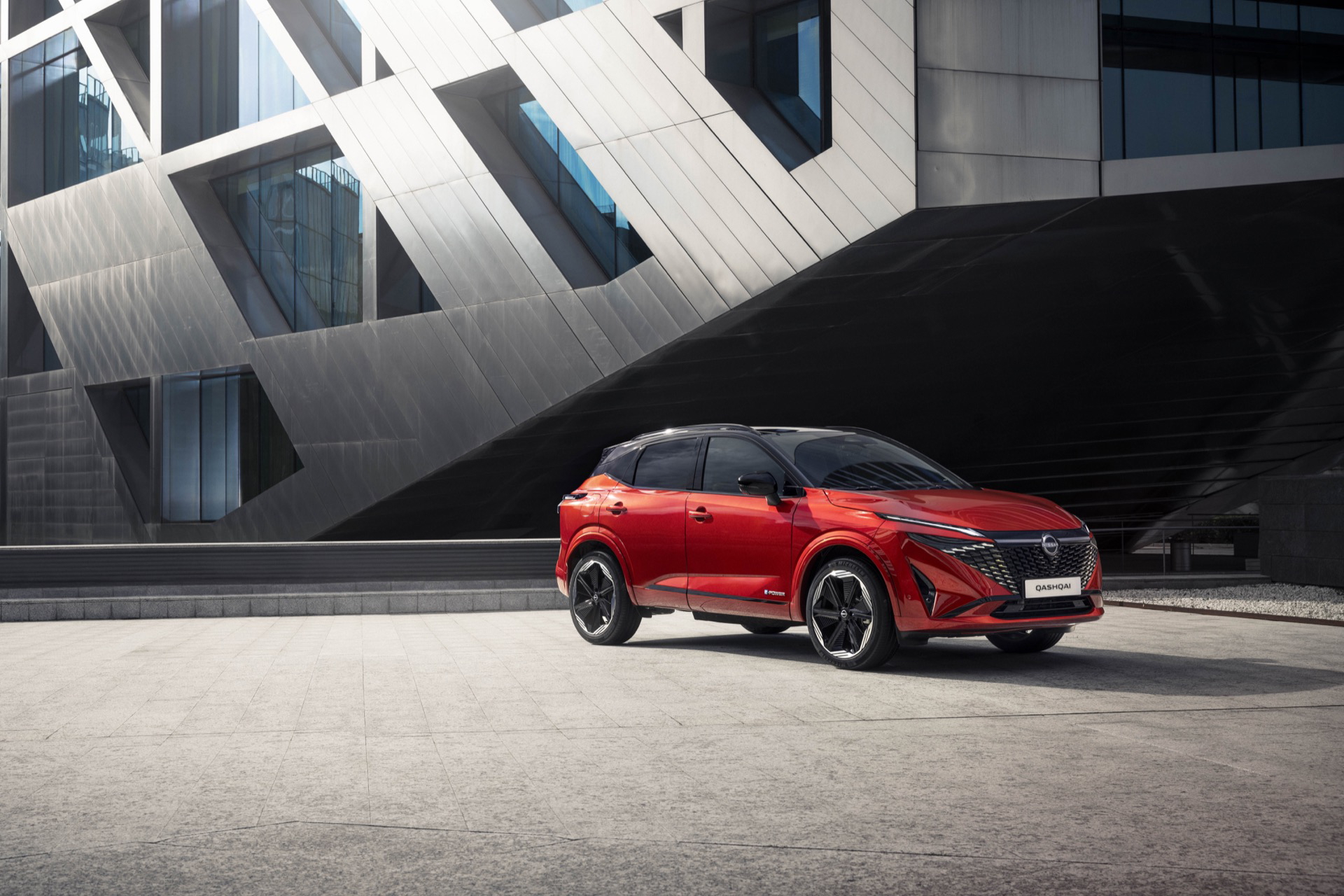 Vista lateral del nuevo Nissan Qashqai 2024 en color rojo, destacando su línea dinámica y moderna.