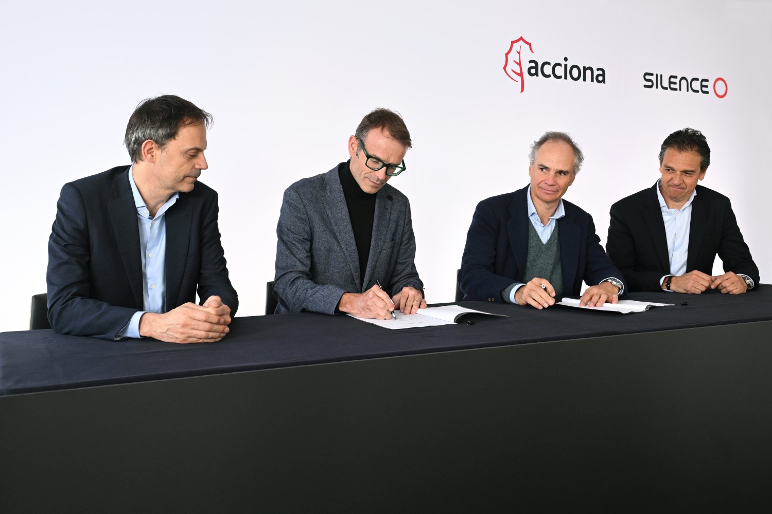 Cuatro ejecutivos durante la firma de un acuerdo importante.