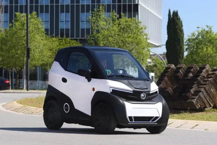 Vista lateral y delantera del compacto eléctrico, enfocando en su diseño urbano y líneas futuristas Vista lateral y delantera del compacto eléctrico, enfocando en su diseño urbano y líneas futuristas