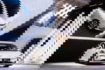 Modelo sedán de lujo captado desde ángulos delantero y lateral, exhibiendo su diseño aerodinámico.