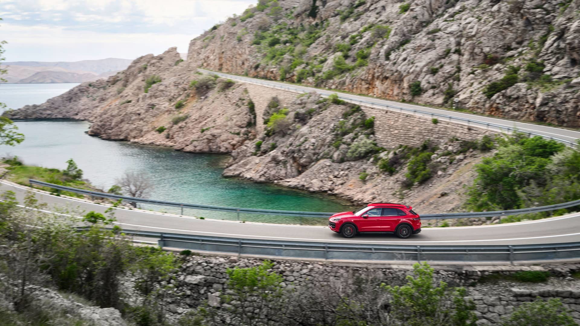 Vista lateral del Porsche Cayenne GTS 2024 navegando por carreteras serpenteantes