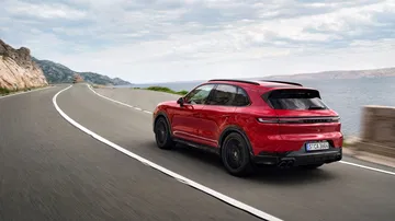 Vista dinámica del Porsche Cayenne GTS 2024 en carretera, destacando su diseño deportivo.