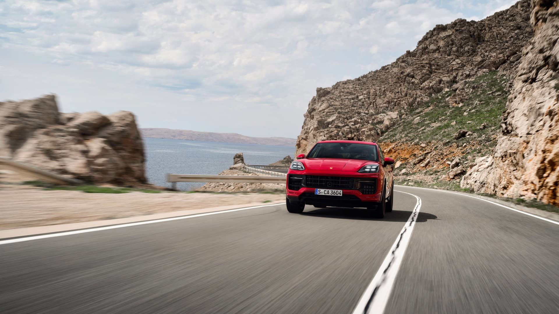 Vista dinámica del Porsche Cayenne GTS 2024 abordando una curva con elegancia.