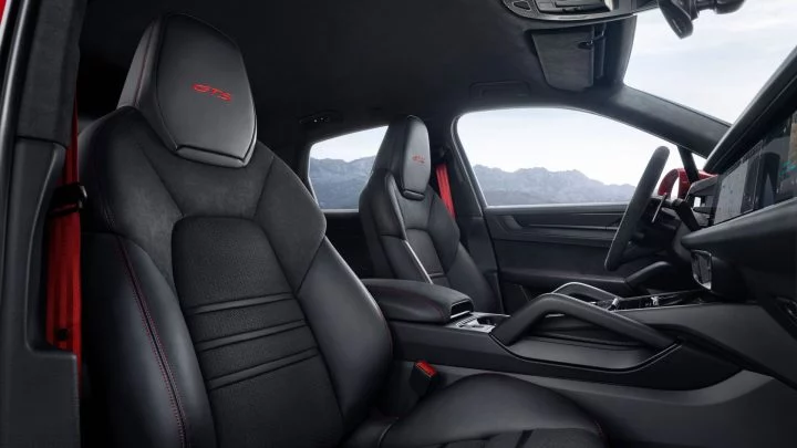 Vista de los asientos deportivos GTS del Porsche Cayenne 2024 con costuras rojas contrastantes.