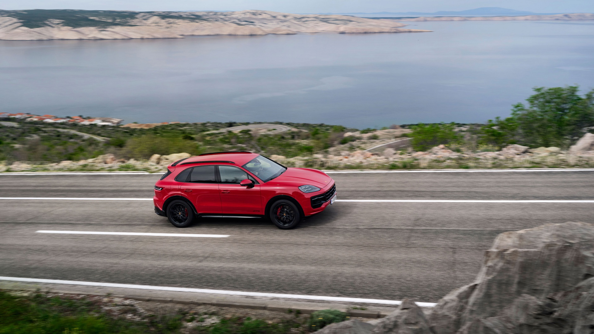 El Porsche Cayenne GTS 2024 luce su silueta dinámica en carretera abierta.